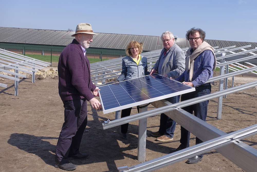 Bestuur WeertEnergie legt eerste zonnepaneel op Zonnepark Altweerterheide